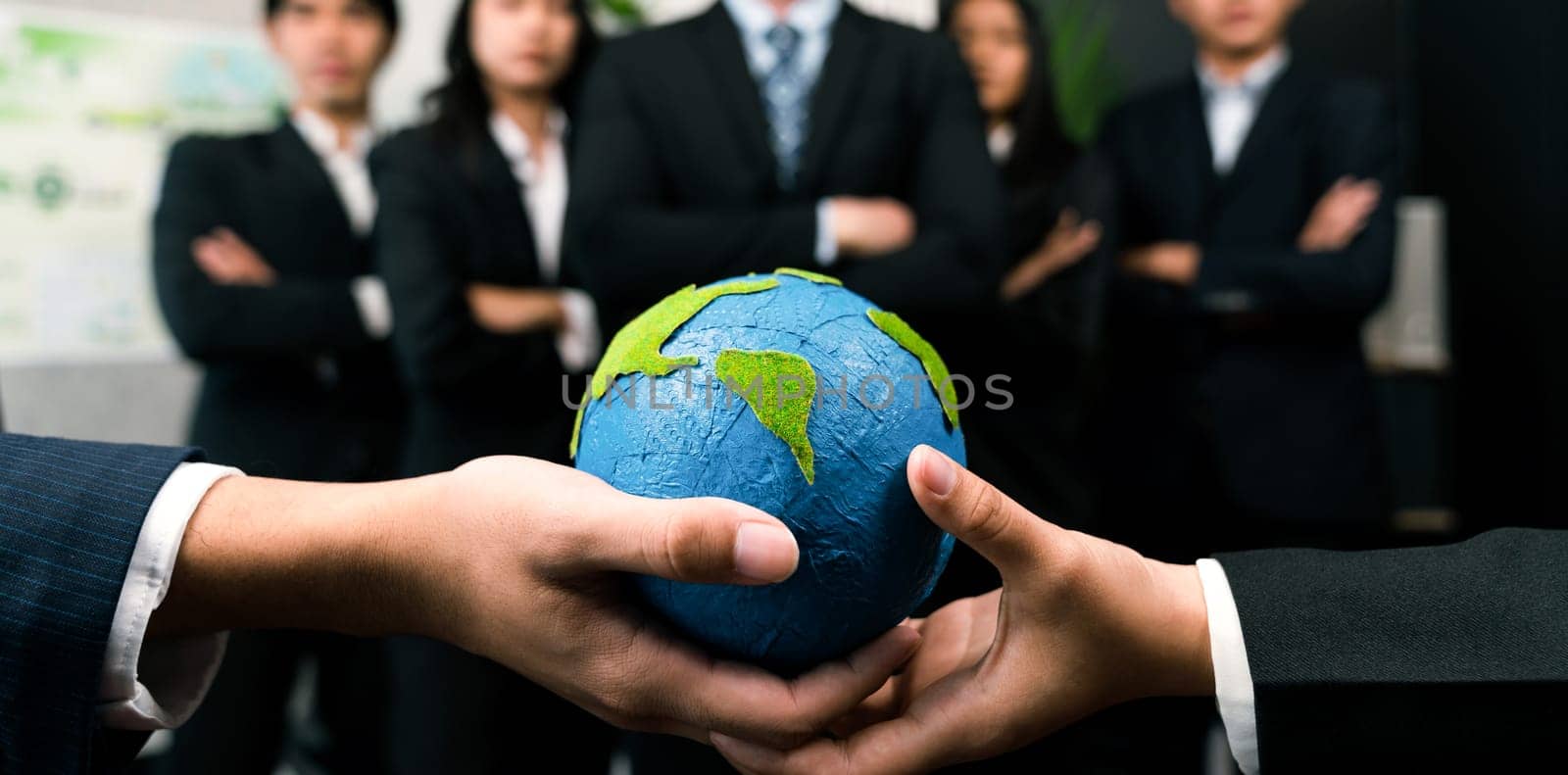 Top view business people holding Earth together in synergy as team building to utilize eco regulation for environmental protection by reducing CO2 emission to save Earth. Quaint