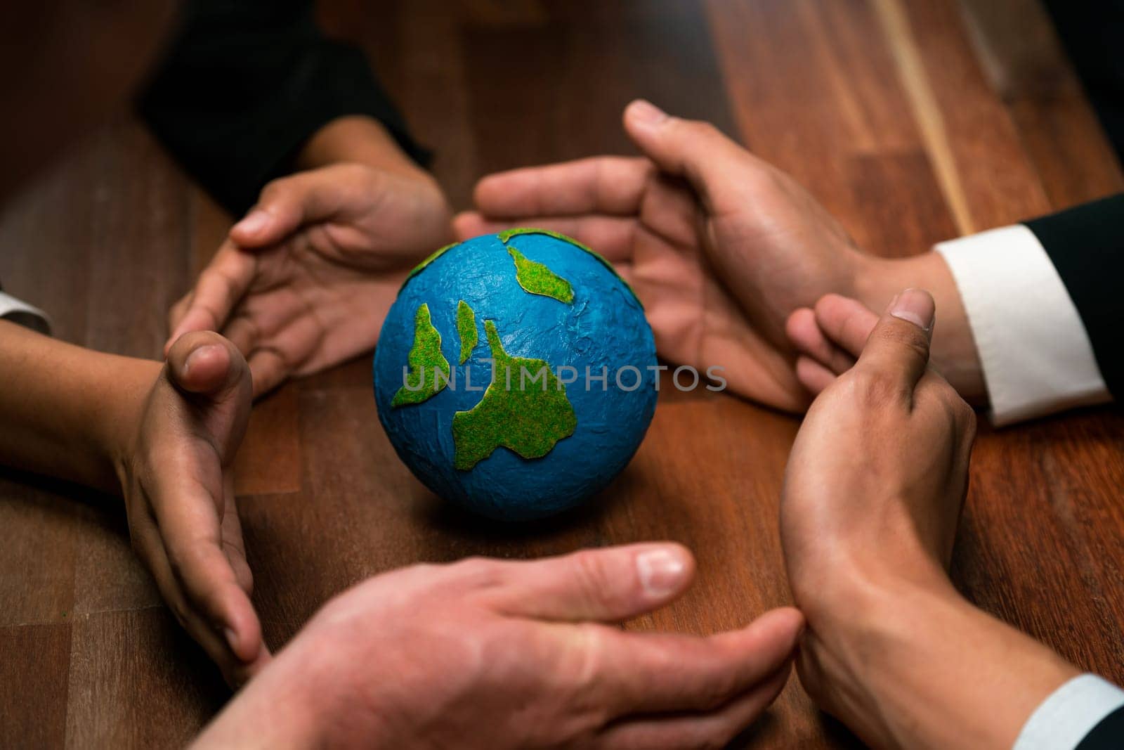 Top view business people holding Earth together in synergy as team building to utilize eco regulation for environmental protection by reducing CO2 emission to save Earth. Quaint