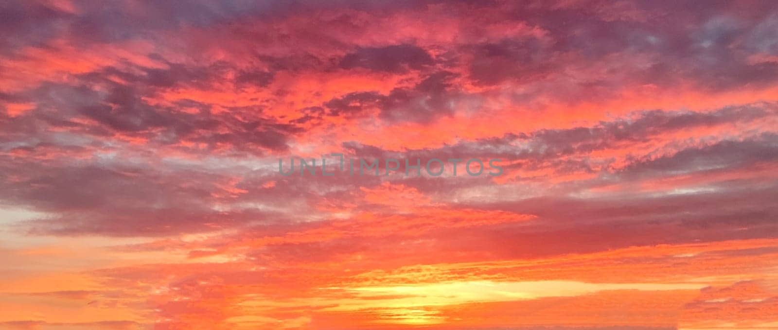 setting sun on a lilac orange cloudy sky for a dramatic sky background by Annado