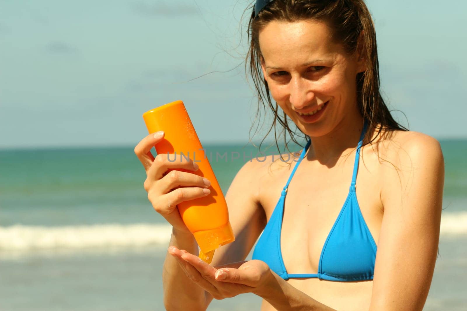 Woman applying sunscreen on the beach