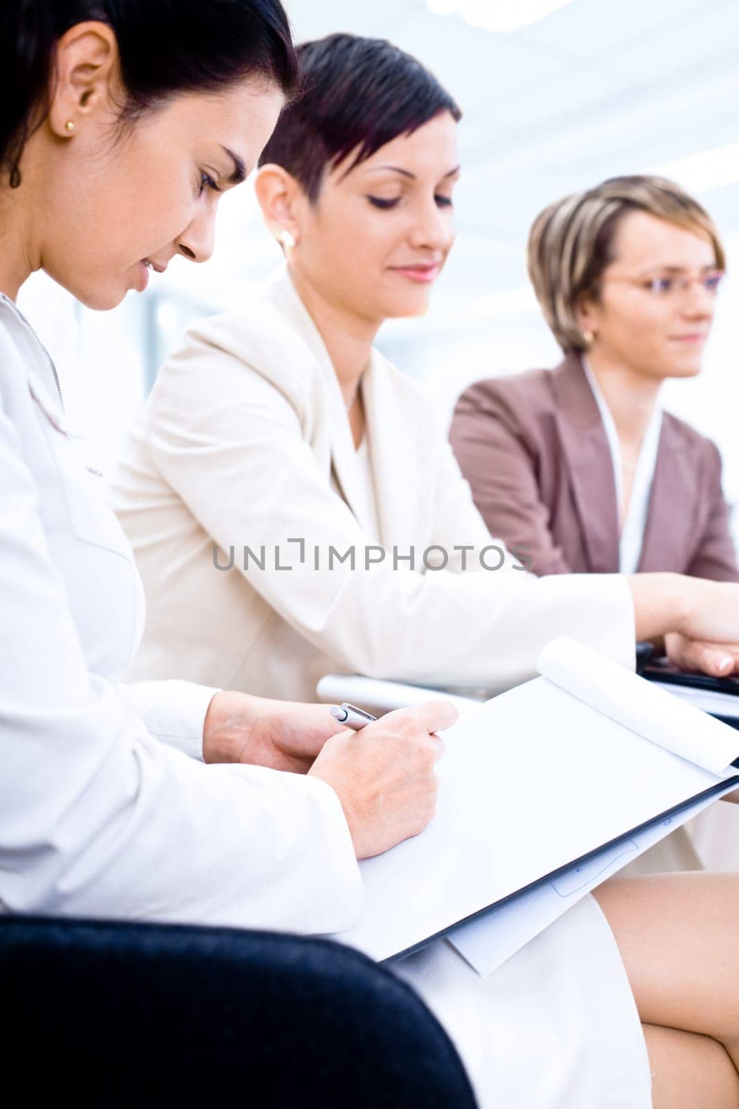 Businesswomen writing notes on training