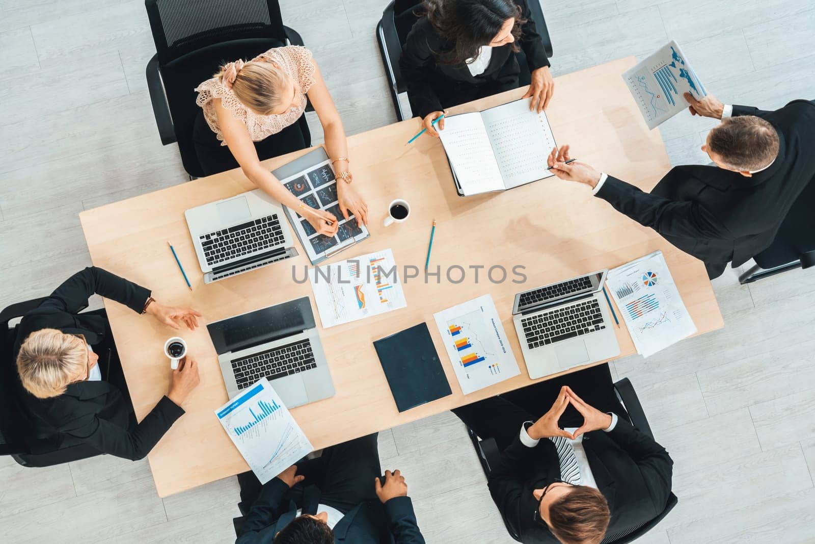 Business people group meeting shot from top view in office . Profession businesswomen, businessmen and office workers working in team conference with project planning document on meeting table . Jivy