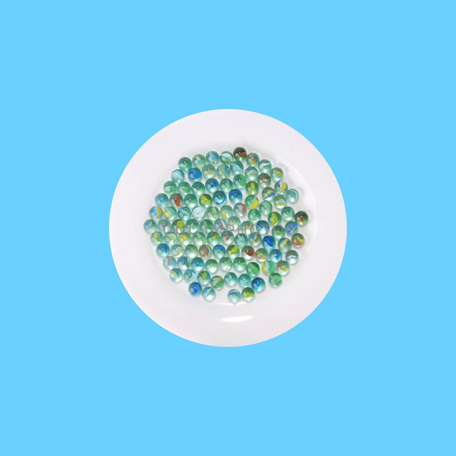 Plate with glass marbles from above - blue