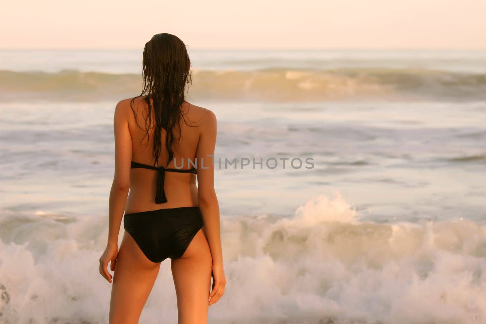 Woman by the sea at sunset