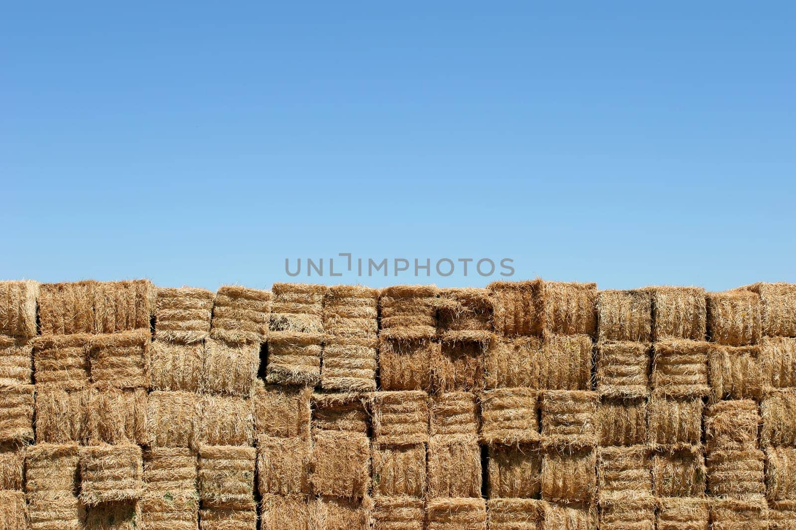 hay bales wall against blue sky