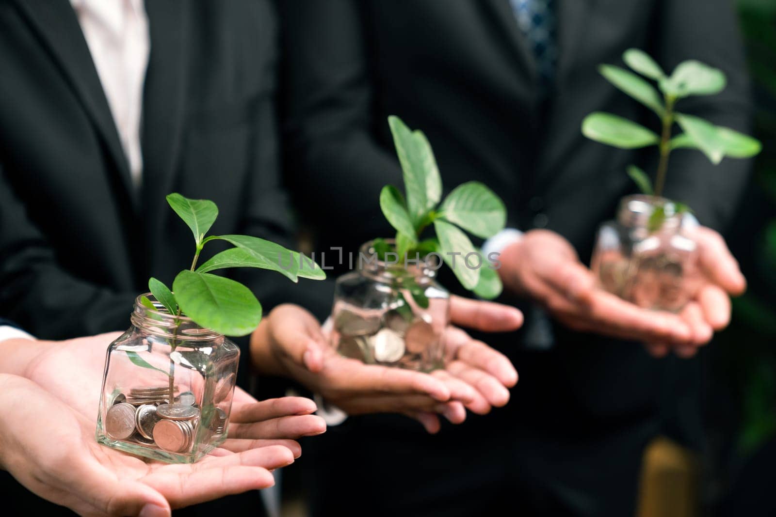 Business people holding money savings jar filled with coins and growing plant for sustainable financial planning for retirement or eco subsidy investment for environment protection. Quaint