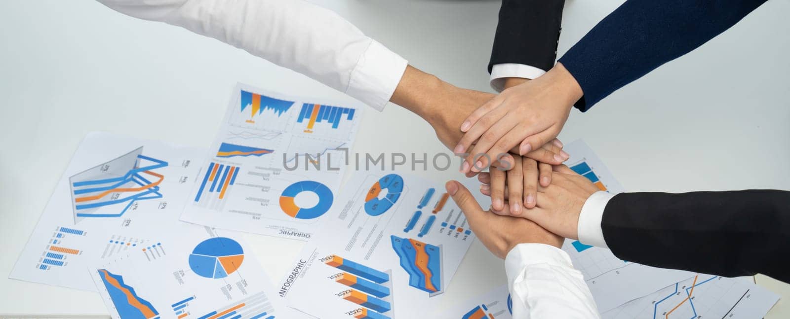 Analyst team putting hand together after successful plan of business strategy and marketing. Teamwork friends and unity cooperation in office with stack hands. Panoramic shot. oratory