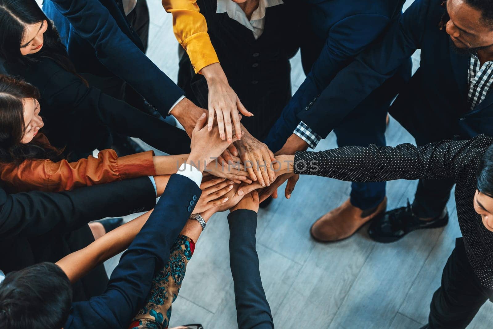 A group of diversity people putting their hands together. Showing unity teamwork and friendship. Close up top view of young business man and business woman joining as a team. Intellectual.