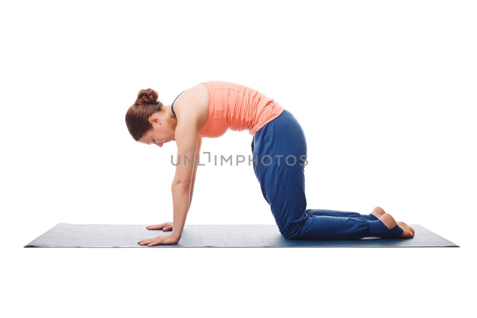 Beautiful sporty fit yogini woman practices yoga asana marjariasana - cat pose gentle warm up for spine (also called cat-cow pose) isolated on white