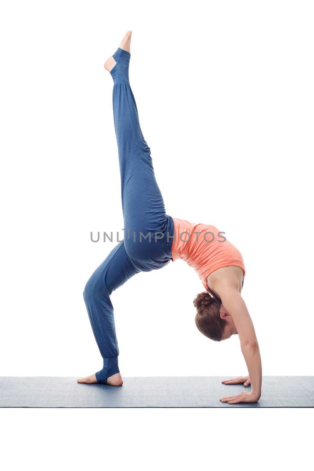 Beautiful sporty fit yogini woman practices yoga asana eka pada chakrasana (or eka pada urdva dhanurasana) - one-legged wheel pose (or one-legged upward facing bow) pose isolated on white