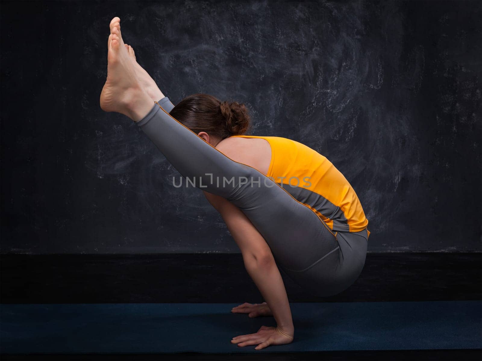 Beautiful sporty fit yogi girl practices yoga asana titibhasana by dimol