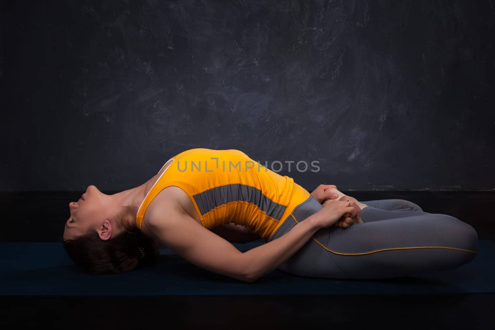 Beautiful sporty fit yogi girl practices yoga asana Matsyasana by dimol