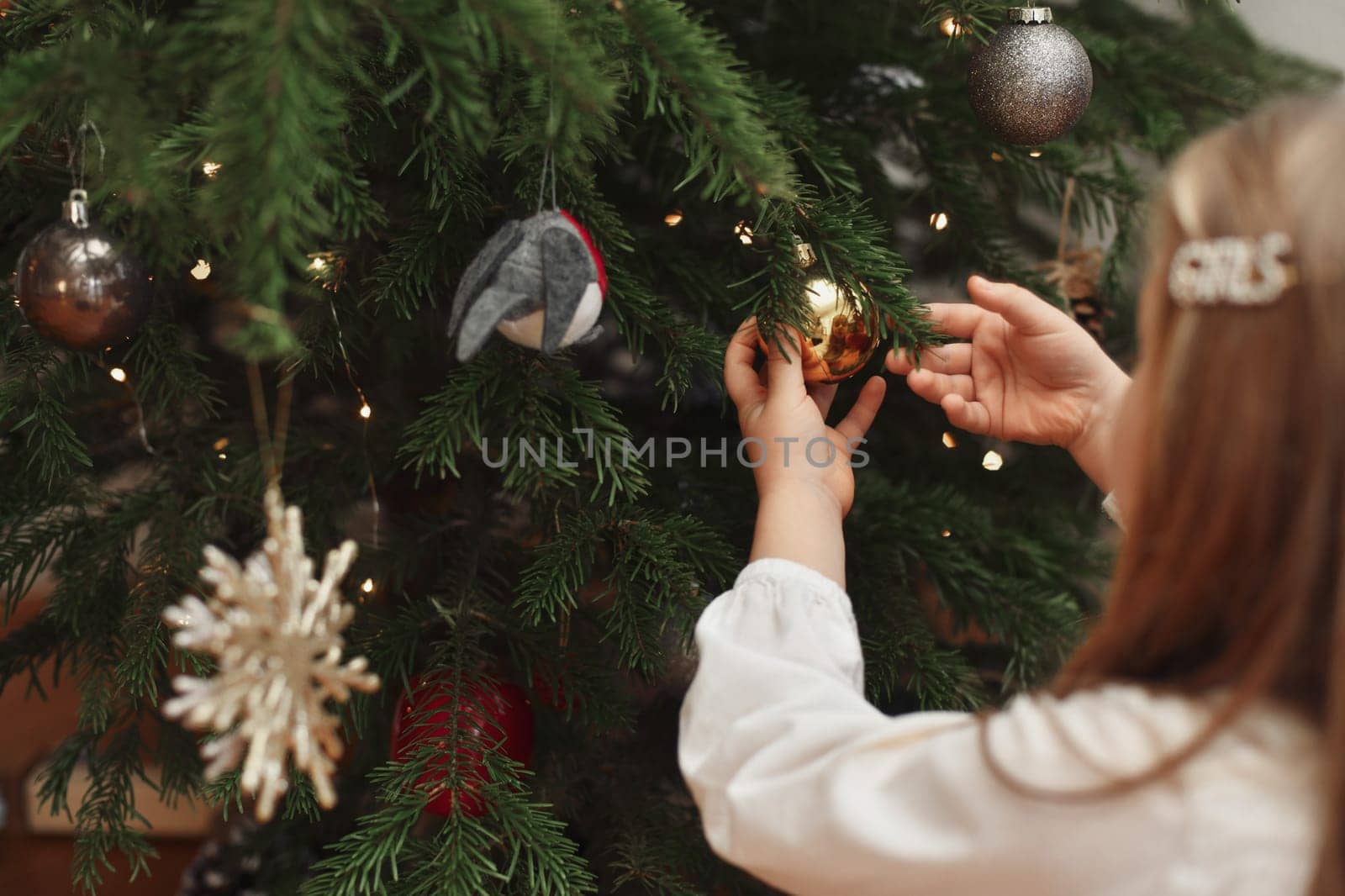 Girl decorates a tree for Christmas