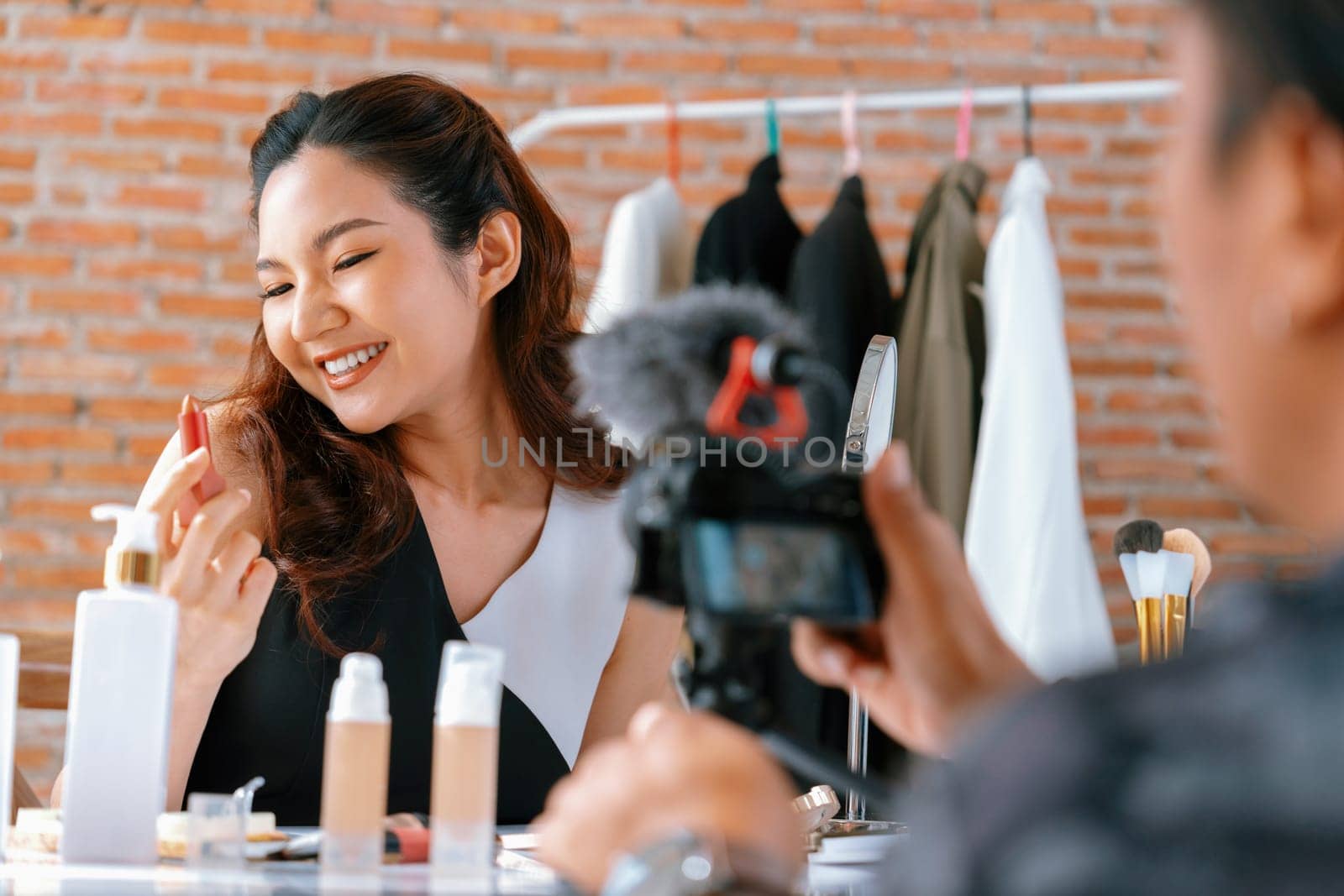 Woman influencer shoot live streaming vlog video review makeup uttermost social media or blog. Happy young girl with cosmetics studio lighting for marketing recording session broadcasting online.