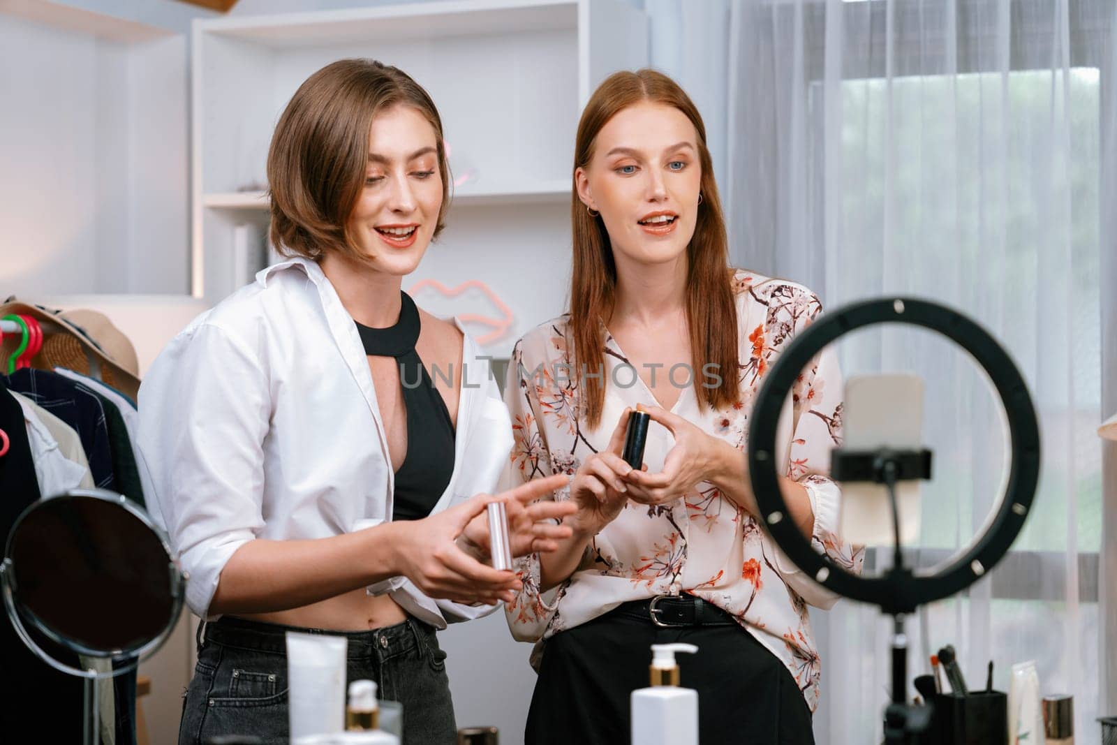 Woman influencer shoot live streaming vlog video review makeup utmost social media or blog. Happy young girl with cosmetics studio lighting for marketing recording session broadcasting online.