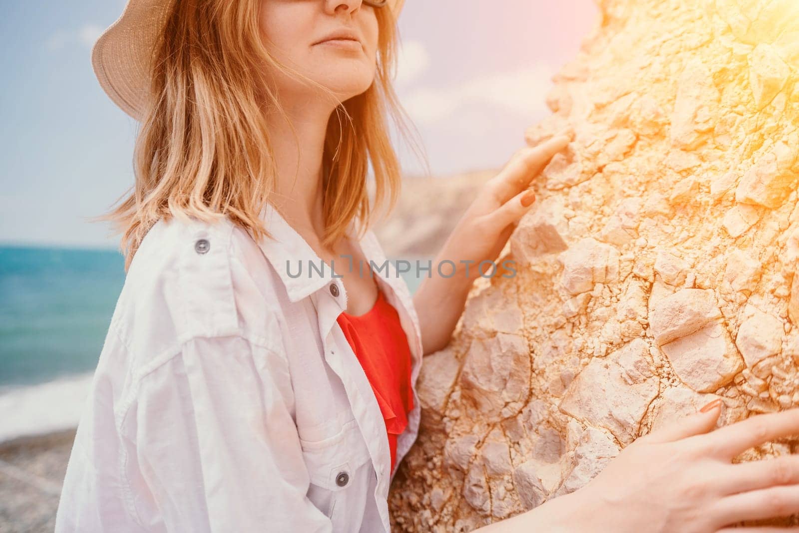 Young woman in red bikini on Beach. Blonde in sunglasses on pebble beach enjoying sun. Happy lady in one piece red swimsuit relaxing and sunbathing by turquoise sea ocean on hot summer day. Close up,