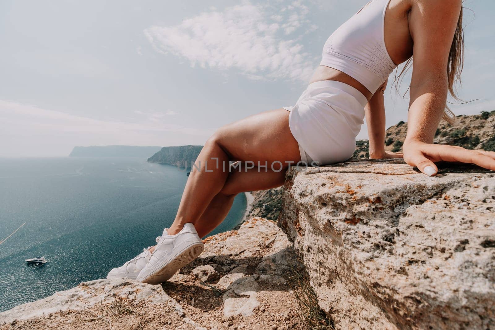 Middle aged well looking woman with black hair doing Pilates with the ring on the yoga mat near the sea on the pebble beach. Female fitness yoga concept. Healthy lifestyle, harmony and meditation.