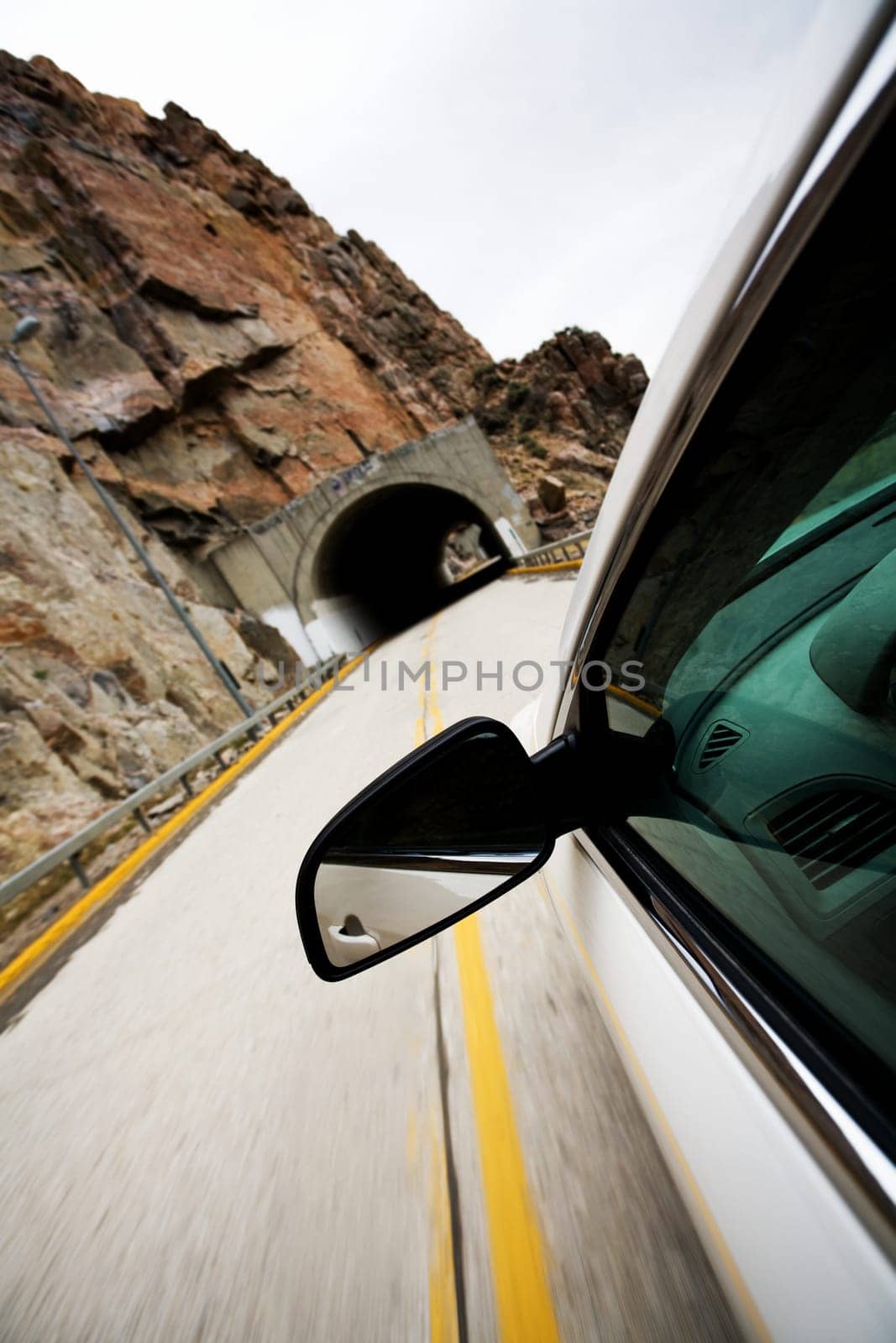 car approacting tunnel through mountains
