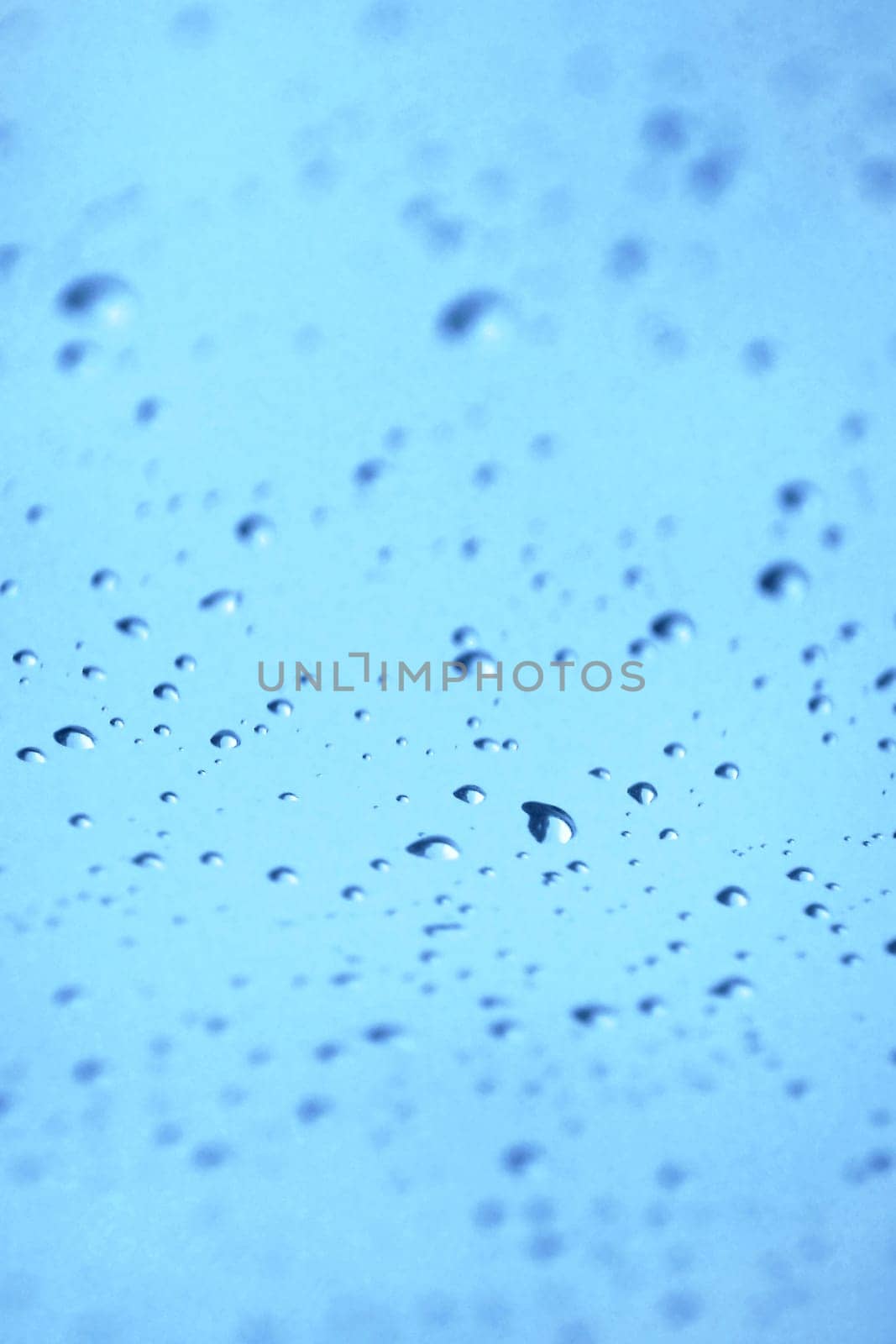 Water drops on glass with blue sky
