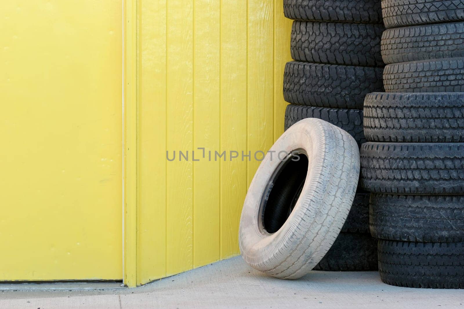 stack of tires against yellow wall