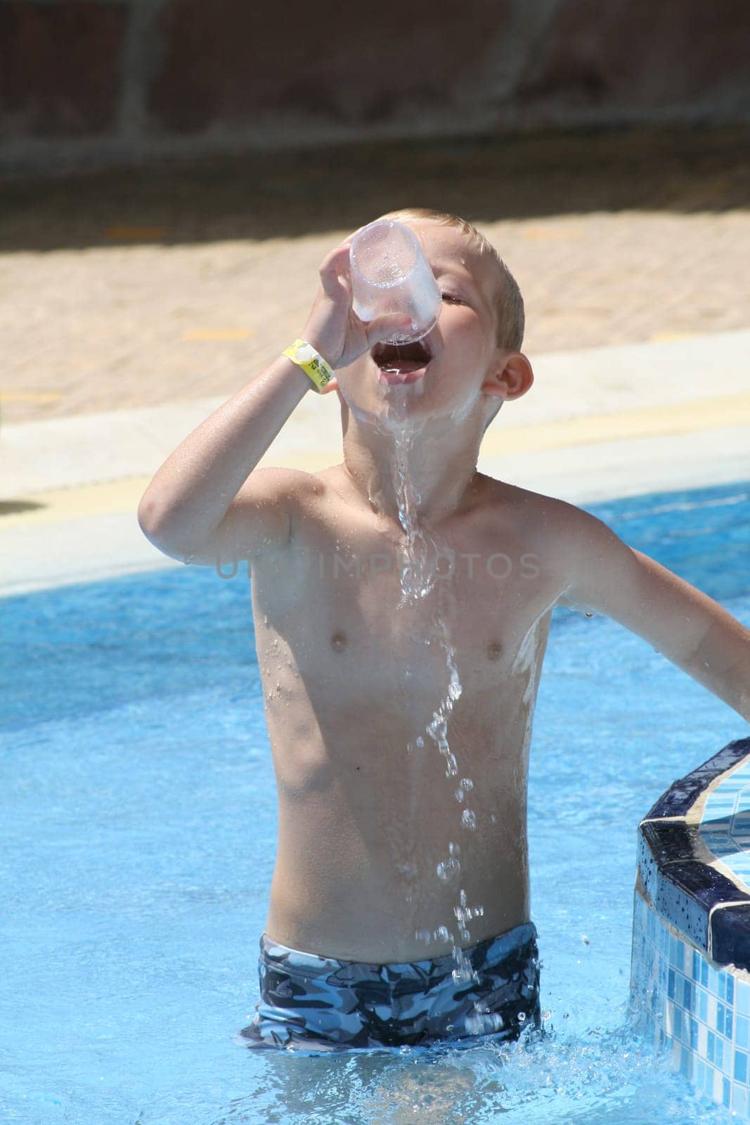 Boy playing with water in pool