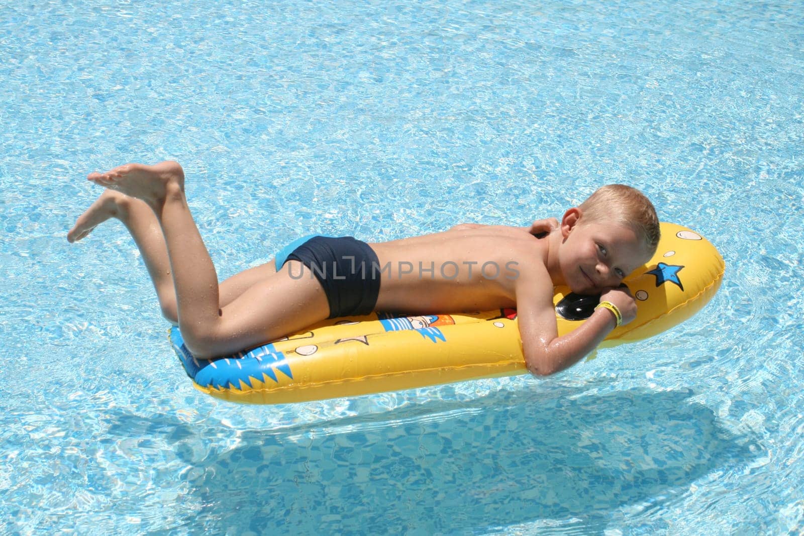 Boy on air mattress in pool