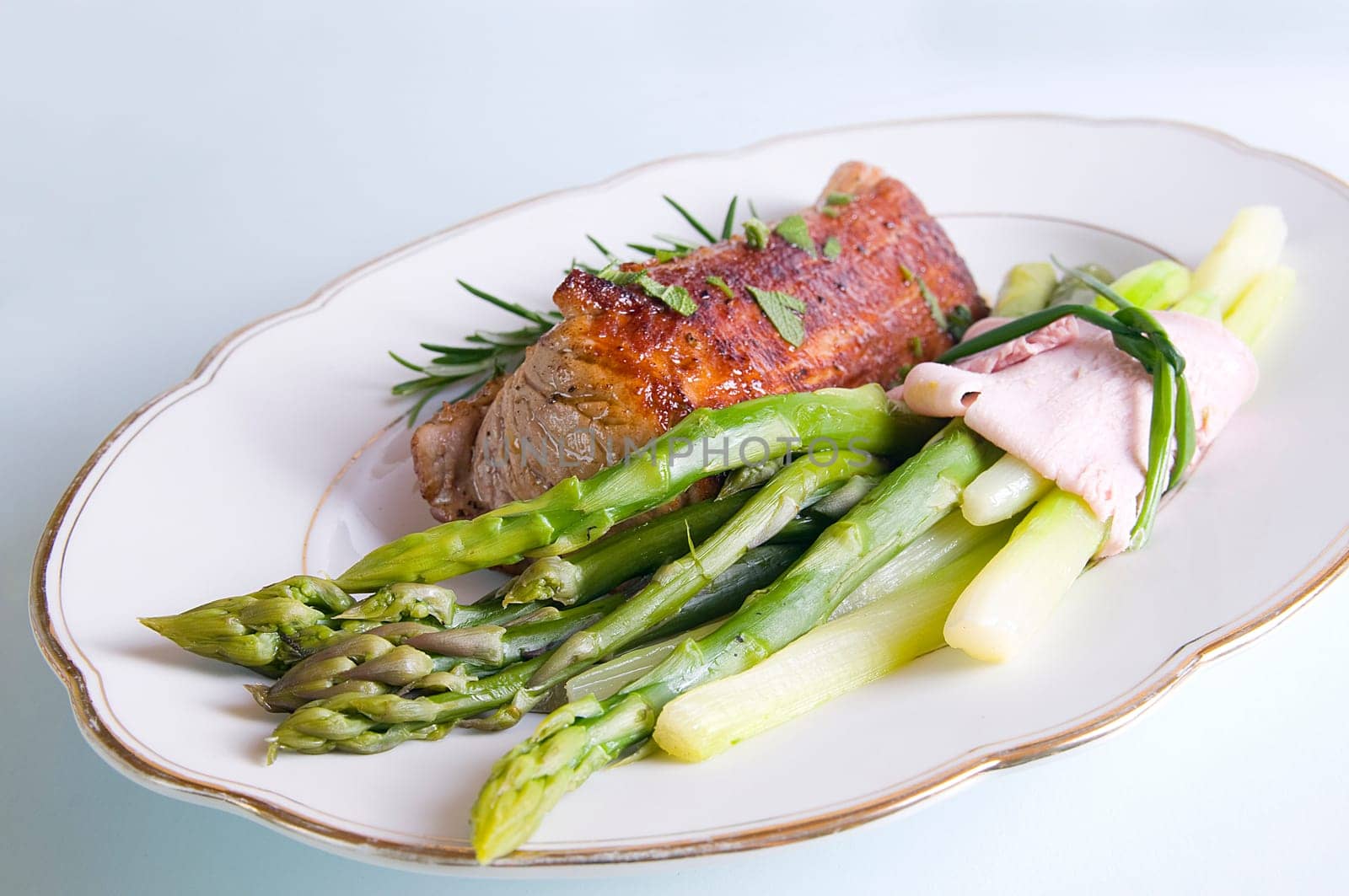 Pork tenderloin with green asparagus on Tel