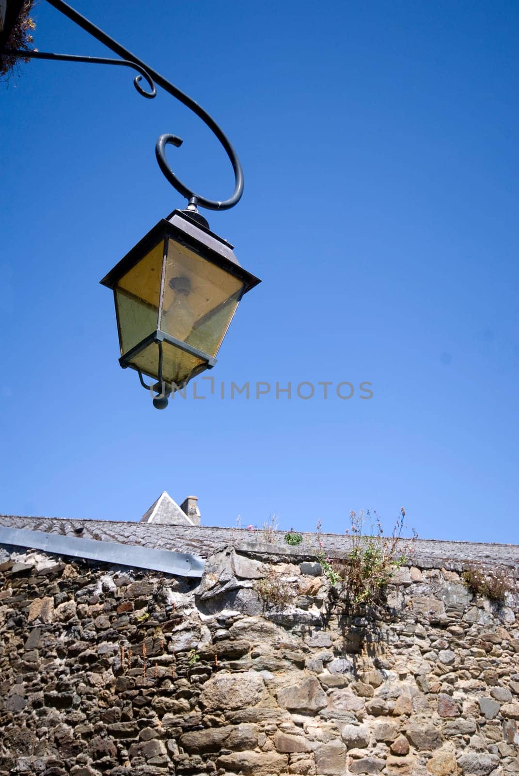 Old street lamp in front of blue sky