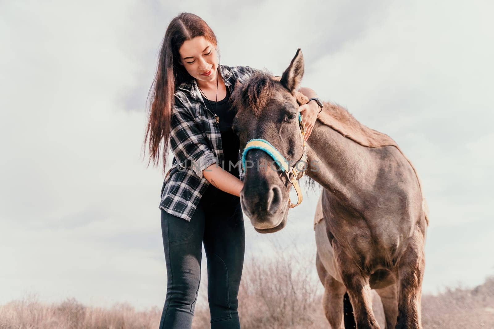 Young happy woman with her pony horse in evening sunset light. Outdoor photography with fashion model girl. Lifestyle mood. Concept of outdoor riding, sports and recreation. by panophotograph