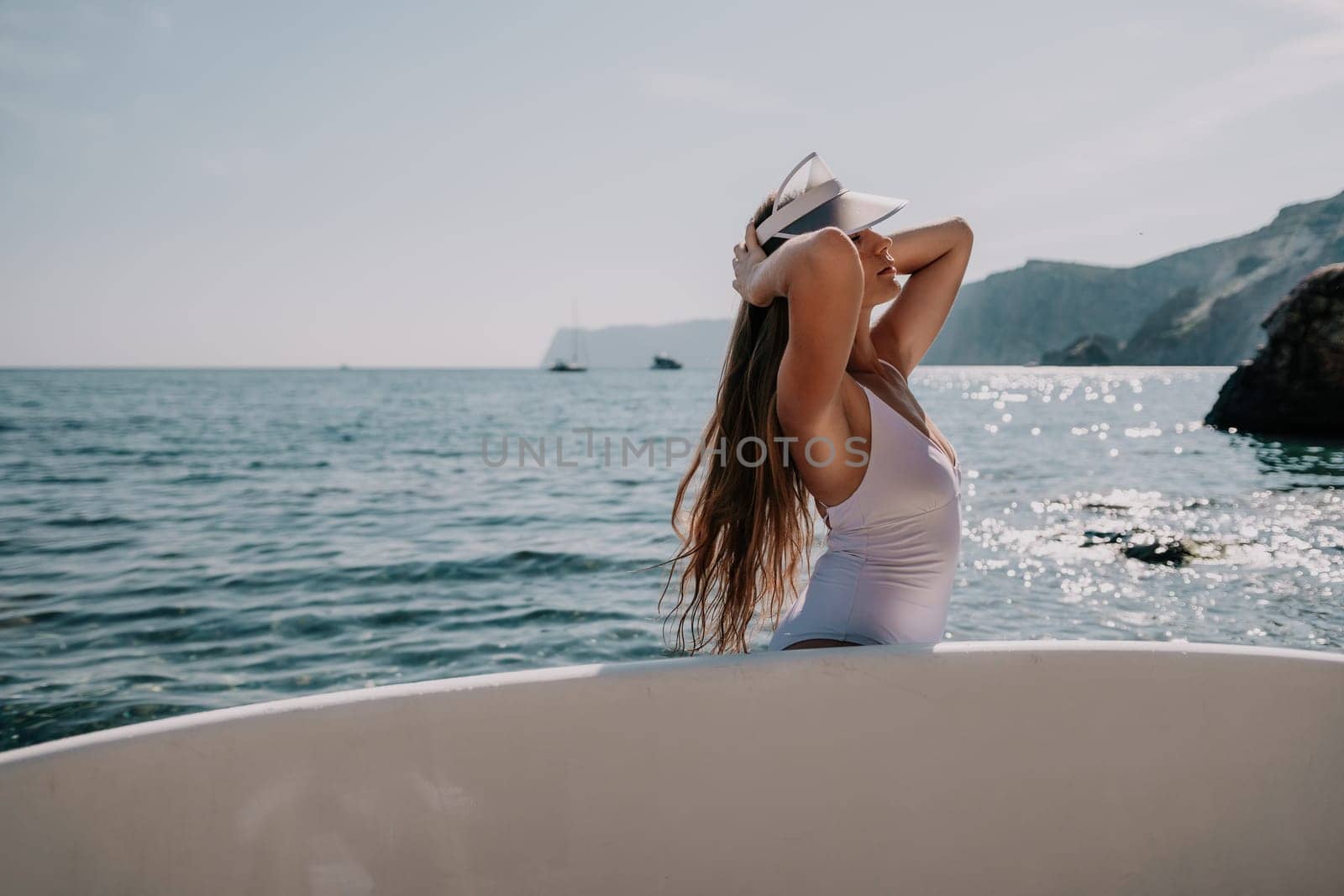 Woman sea sup. Close up portrait of happy young caucasian woman with long hair looking at camera and smiling. Cute woman portrait in a white bikini posing on sup board in the sea by panophotograph