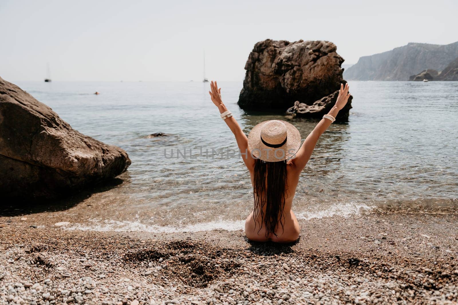 Woman travel sea. Happy tourist in hat enjoy taking picture outdoors for memories. Woman traveler posing on the beach at sea surrounded by volcanic mountains, sharing travel adventure journey by panophotograph