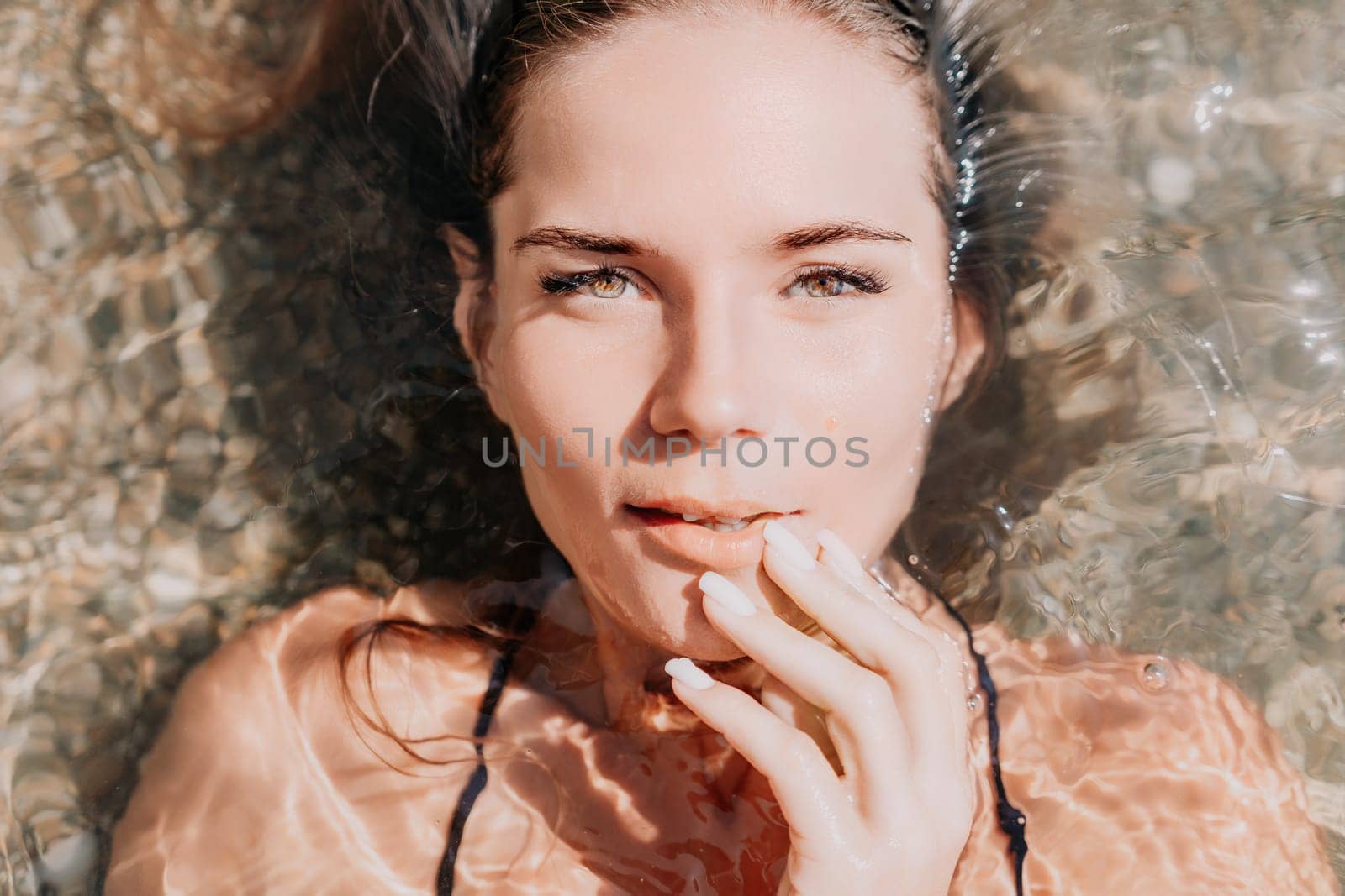 Woman summer travel sea. Happy tourist enjoy taking picture outdoors for memories. Woman traveler posing on the beach at sea surrounded by volcanic mountains, sharing travel adventure journey by panophotograph