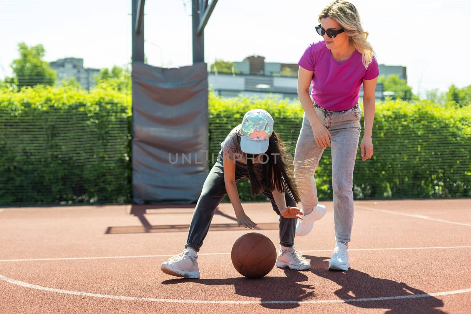 Mother and daughter playing basketball.