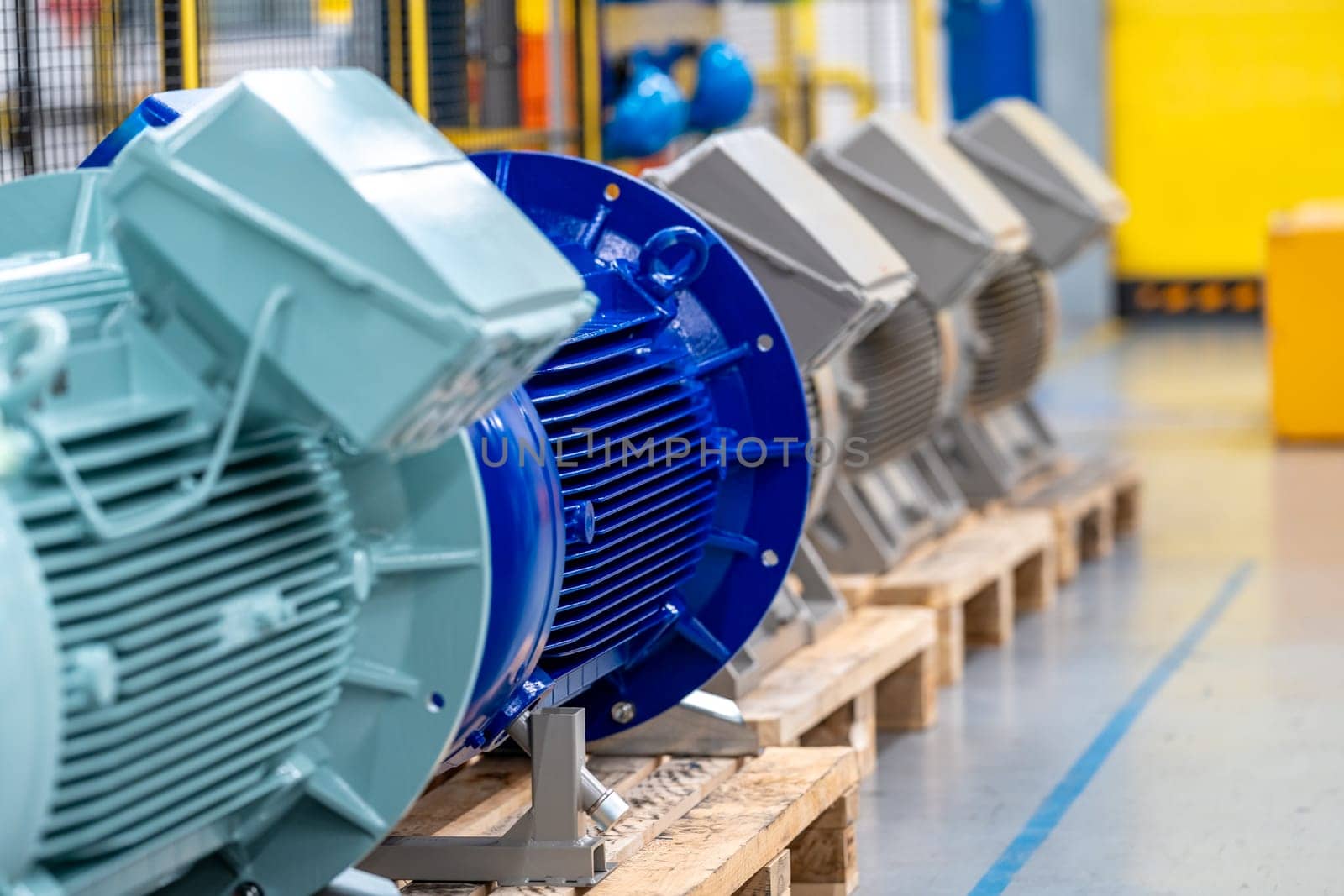 new electric motors different colors and sizes on pallets in the warehouse.