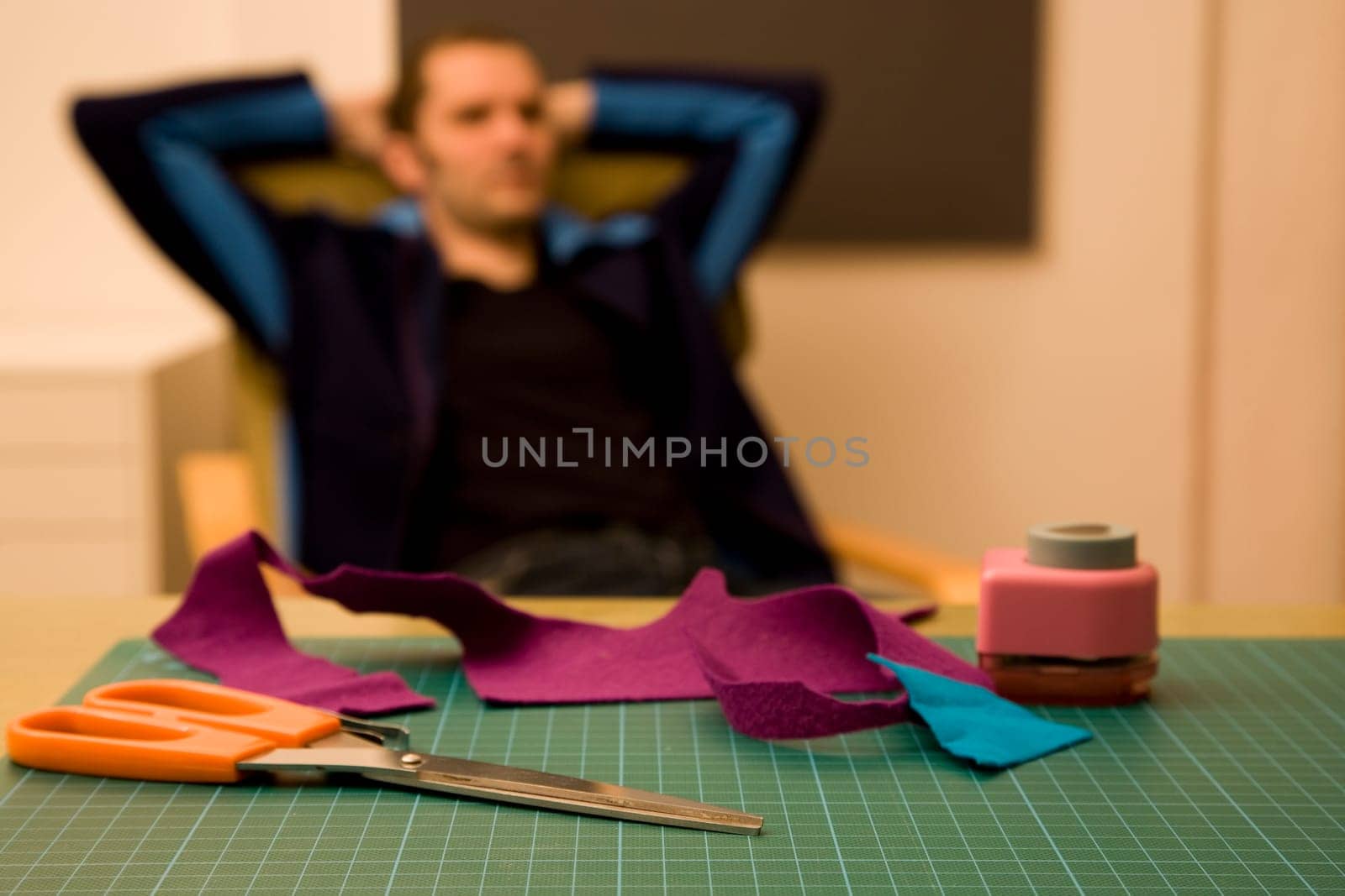 Man with relaxed posture and scissors in foreground