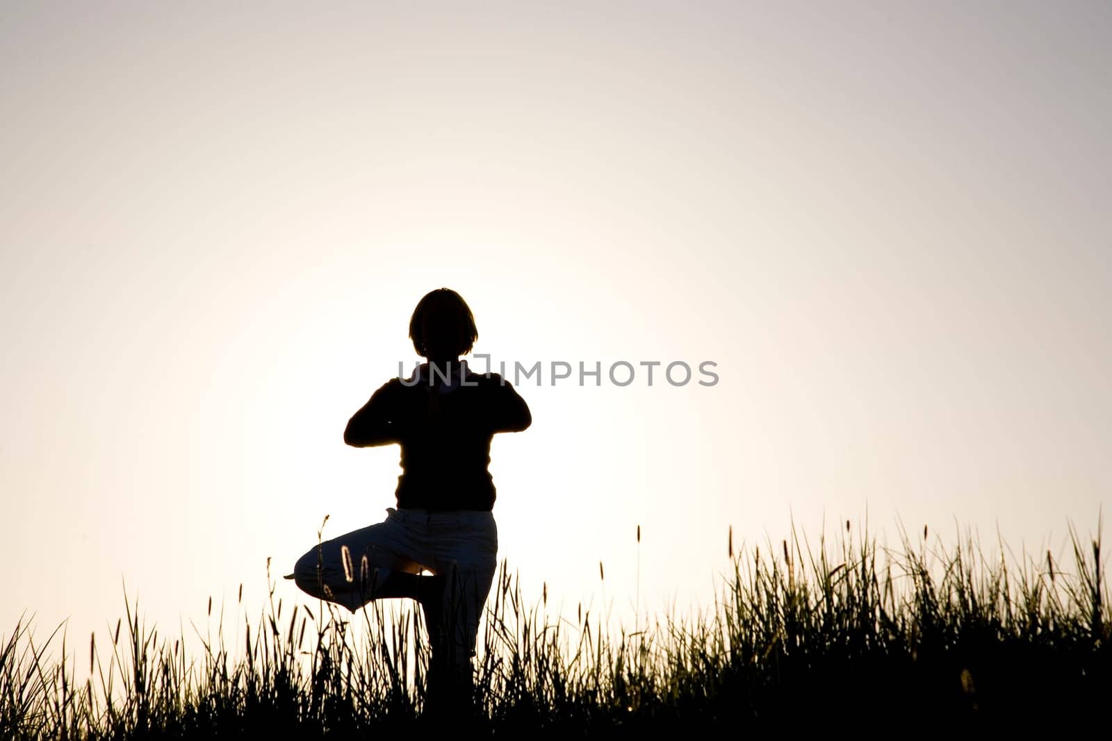 Woman doing yoga exercise - the tree