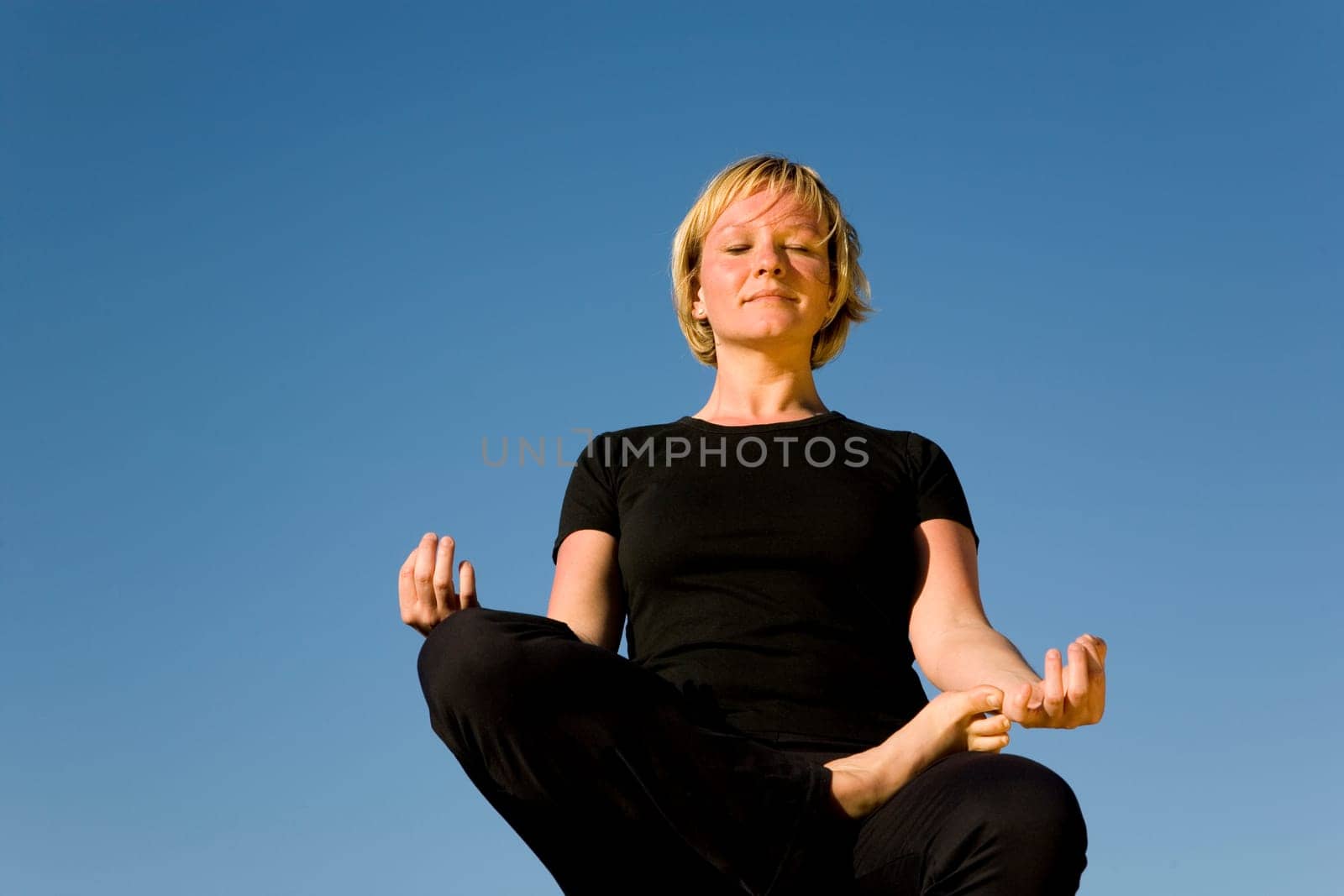 Woman doing yoga exercise - half lotus position