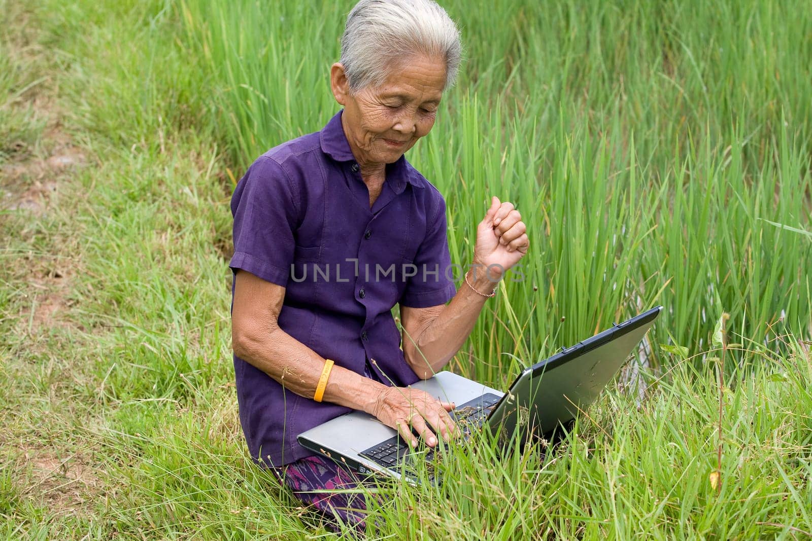 Old Asian woman with laptop