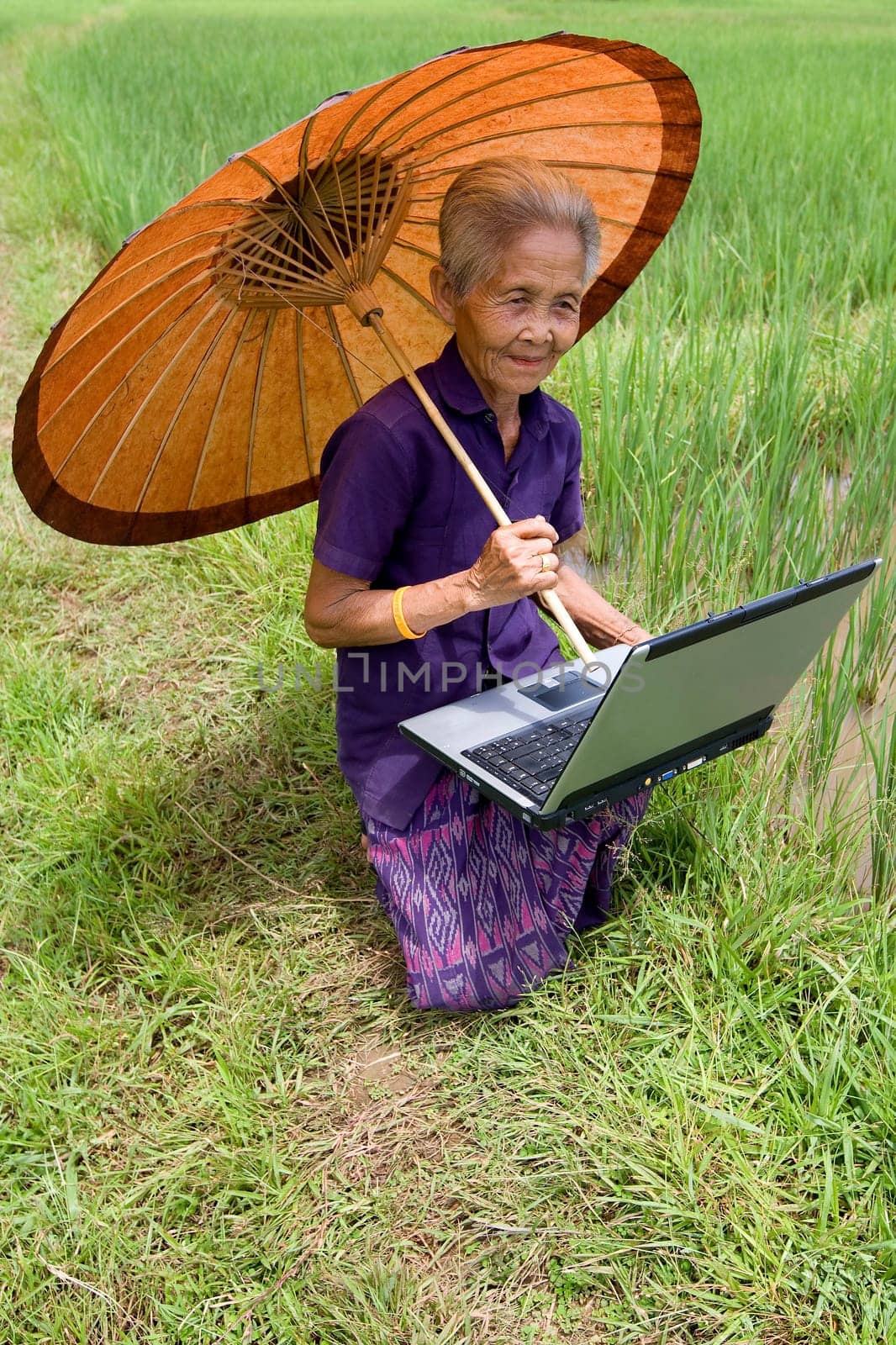 Old Asian woman with laptop
