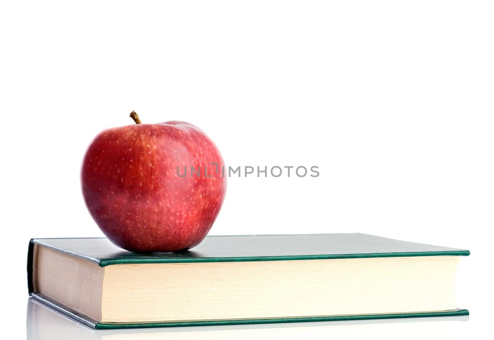 A red apple on a green book