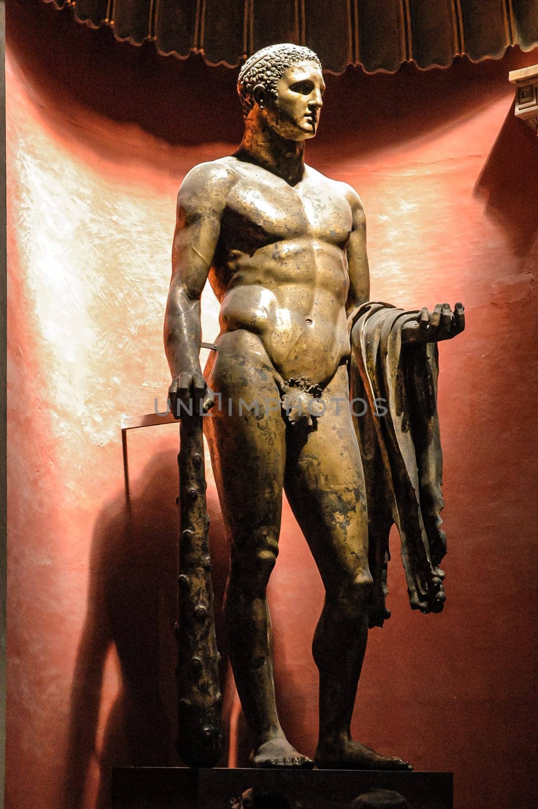 Vatican City, August 21, 2008: Statue of Hercules in gilded bronze carrying the mace and the skin of the Nemean lion. Century III AD. Pio Clementino Museum. Saint Peter Basilica