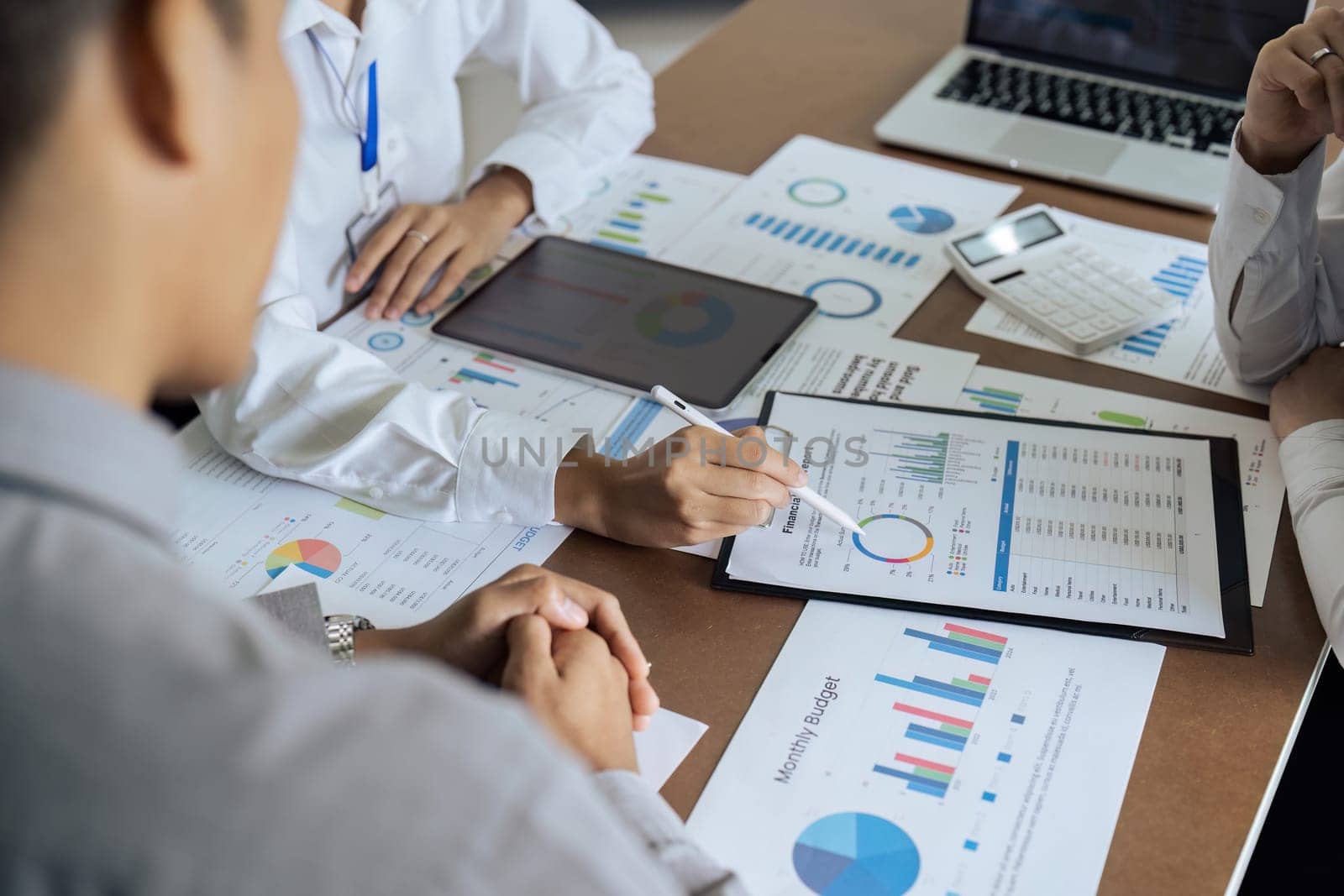 Business people teamwork with analysis cost graph on desk at meeting room by itchaznong