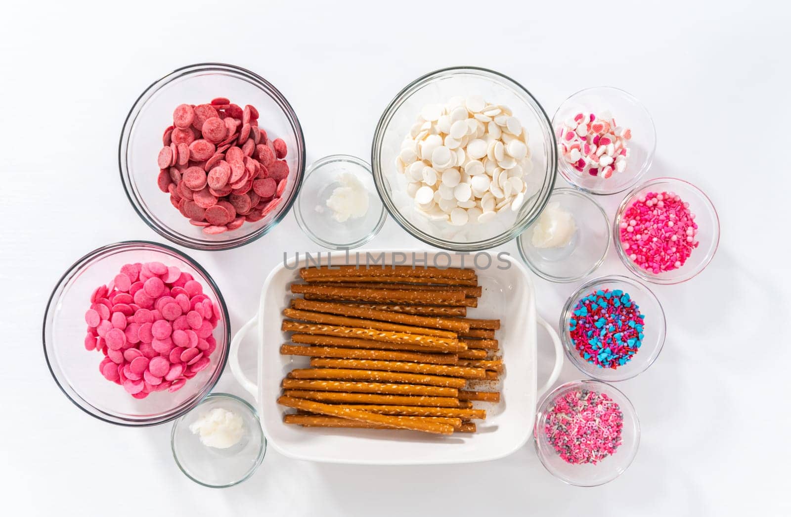 Flat lay. Measured ingredients in glass mixing bowls to make chocolate covered pretzel rods for Valentine's Day.