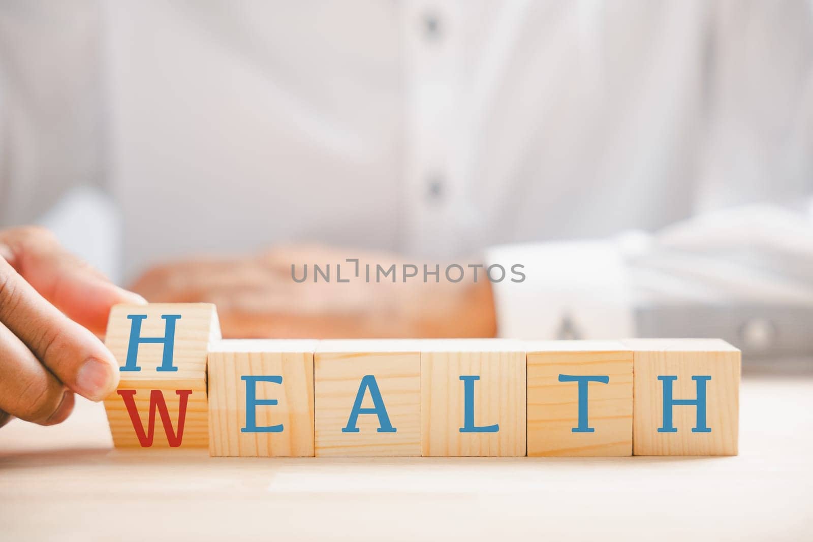 Hand flip wooden cube with word wealth to health by Sorapop