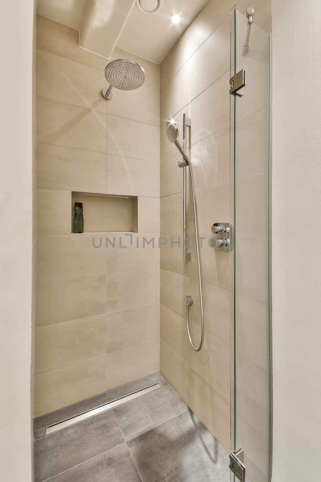 a shower with a glass door in a bathroom by casamedia