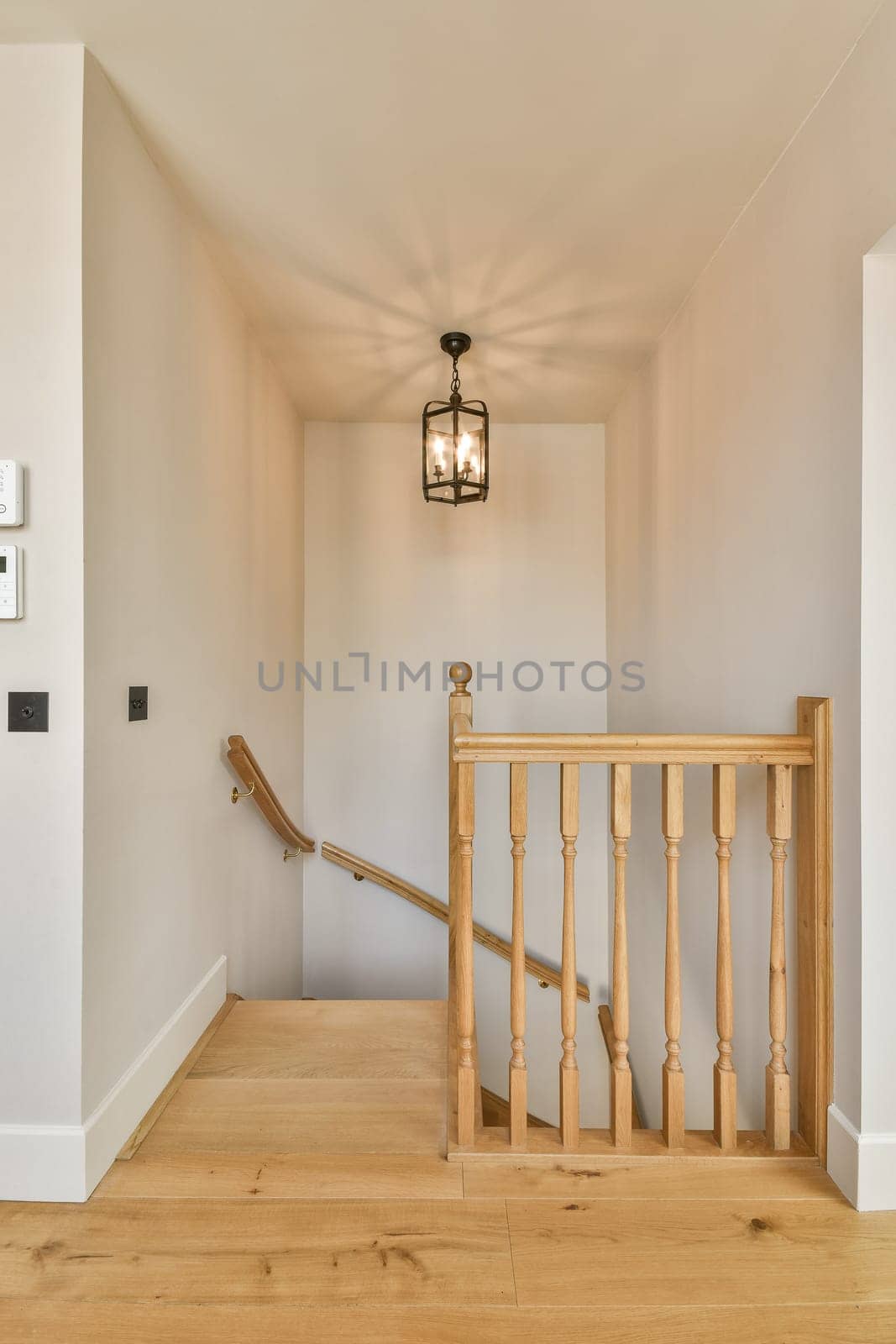 a stairway with a wooden railing and a lantern by casamedia