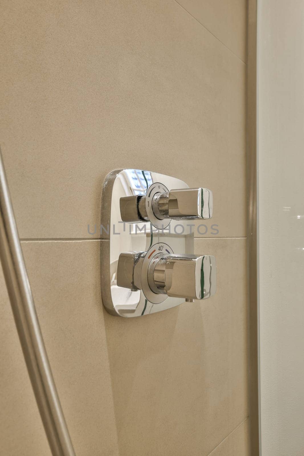 a close up of a shower handle in a bathroom by casamedia