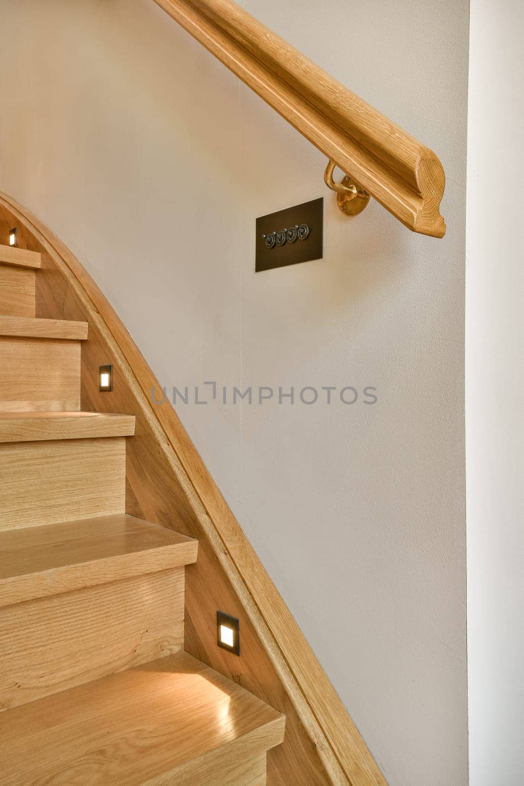 a wooden staircase with a wooden railing and a light by casamedia