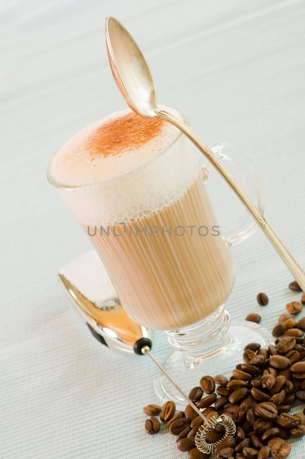 Coffee with milk in a glass with milk foam
