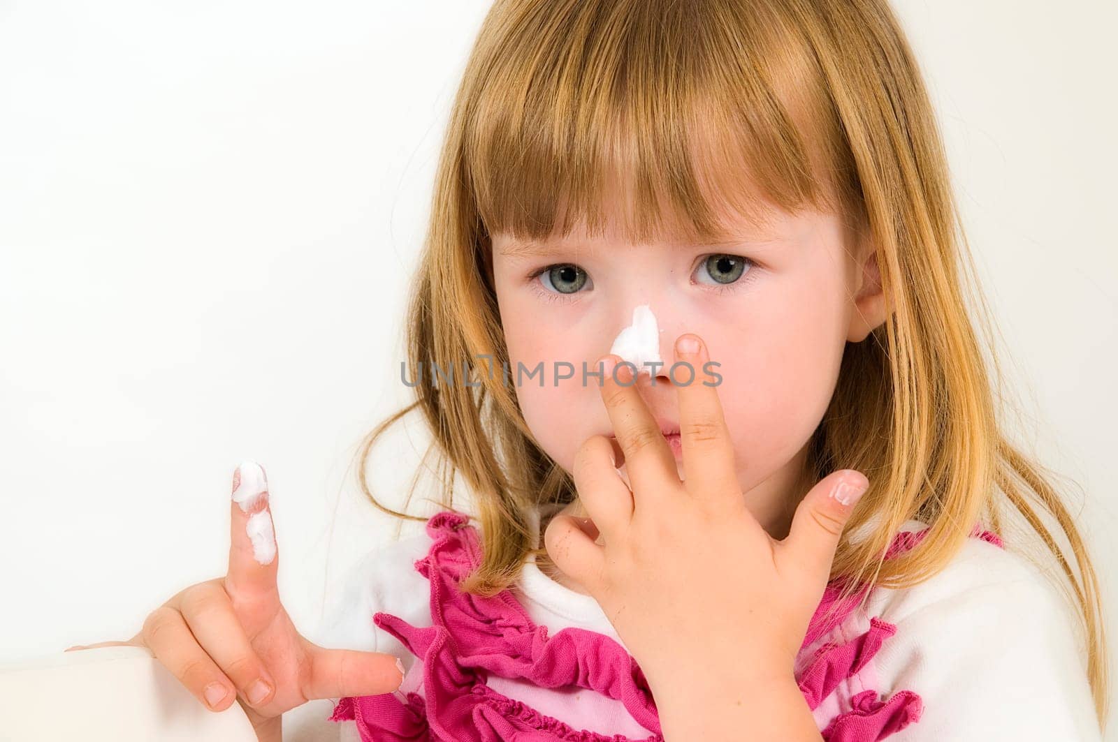 little girl with cream on the nose